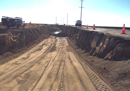 A dirt road with construction equipment on it.