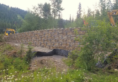 A construction crew is working on a stone wall.