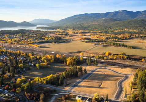 An aerial view of a town in the fall with mountains in the background.