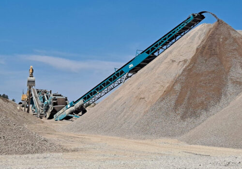 A large pile of gravel with a conveyor belt.